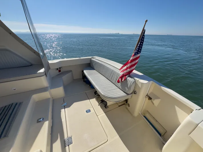 Bay Cruzin Yacht Photos Pics 2004 Mainship Pilot 34 boat with American flag on calm sea.