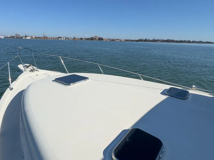 Bay Cruzin Yacht Photos Pics Mainship Pilot 34, 2004, on calm water with cityscape in background.