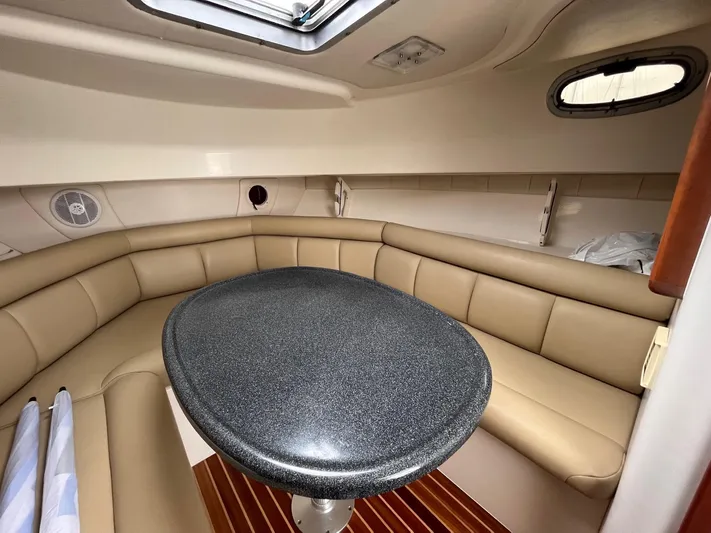  Yacht Photos Pics 2006 Boston Whaler 305 Conquest cabin with beige seating and oval table.