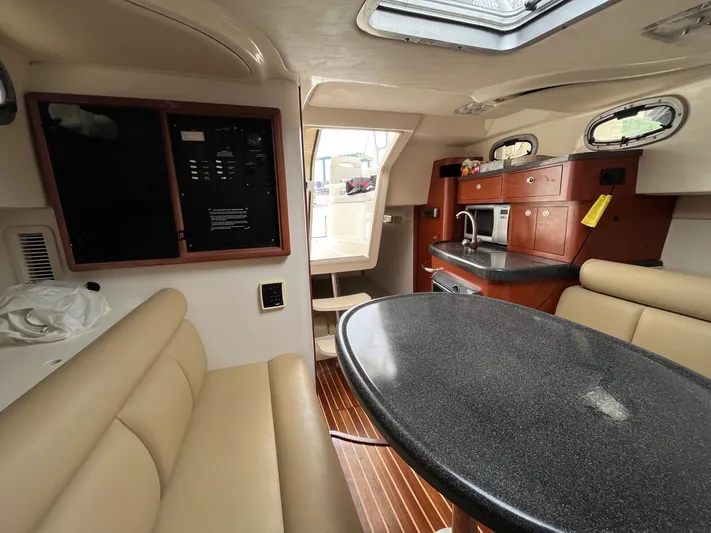 Yacht Photos Pics Interior of 2006 Boston Whaler 305 Conquest, featuring seating, table, and kitchenette.