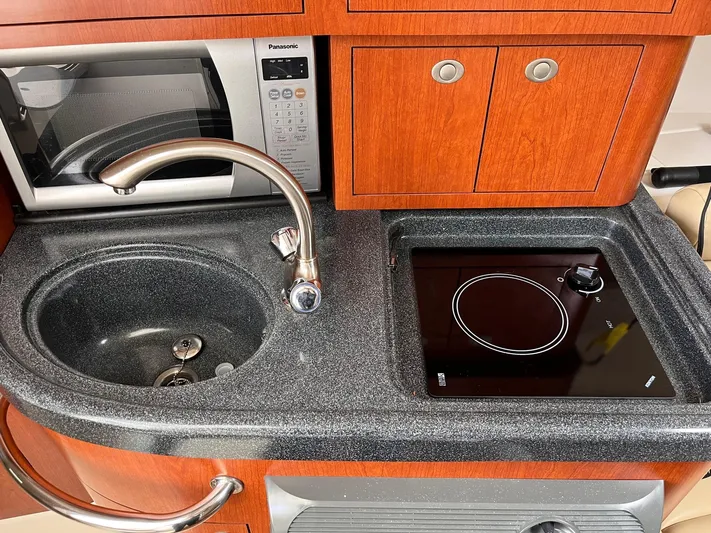  Yacht Photos Pics 2006 Boston Whaler 305 Conquest kitchen with sink, stove, and microwave.