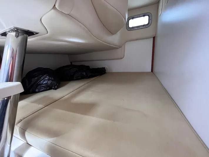  Yacht Photos Pics 2006 Boston Whaler 305 Conquest cabin interior with beige seating and small window.