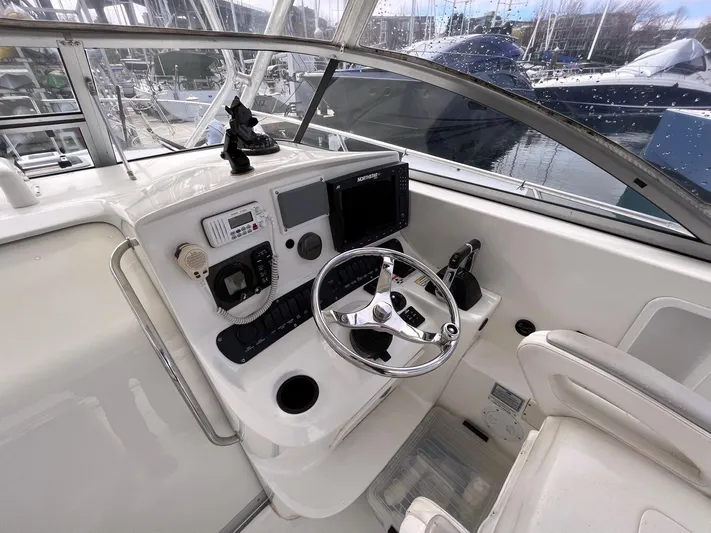  Yacht Photos Pics 2006 Boston Whaler 305 Conquest helm with steering wheel and navigation equipment.