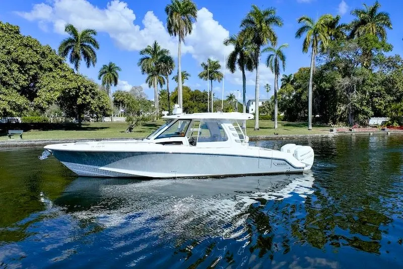 350 Realm Yacht Photos Pics 2019 Boston Whaler 350 Realm boat on water with palm trees in background.