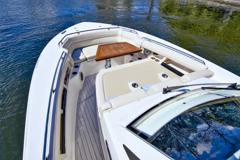 350 Realm Yacht Photos Pics 2019 Boston Whaler 350 Realm boat with spacious seating and wooden table on calm water.