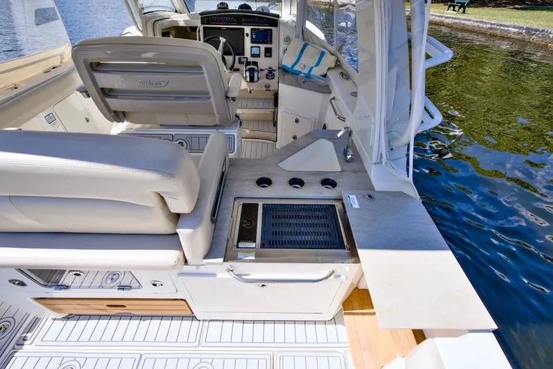 350 Realm Yacht Photos Pics 2019 Boston Whaler 350 Realm interior with helm, seating, and outdoor kitchen by water.