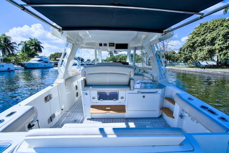 350 Realm Yacht Photos Pics 2019 Boston Whaler 350 Realm boat interior with seating, docked on a sunny day.