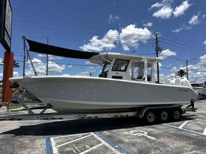  Yacht Photos Pics 2024 Sea Pro 322 DLX boat on trailer under clear blue sky.