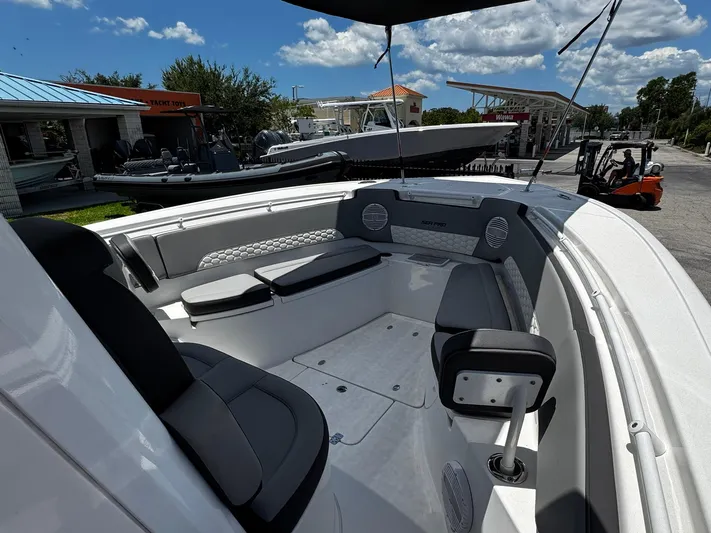  Yacht Photos Pics 2024 Sea Pro 322 DLX boat interior with seating and speakers under a sunny sky.