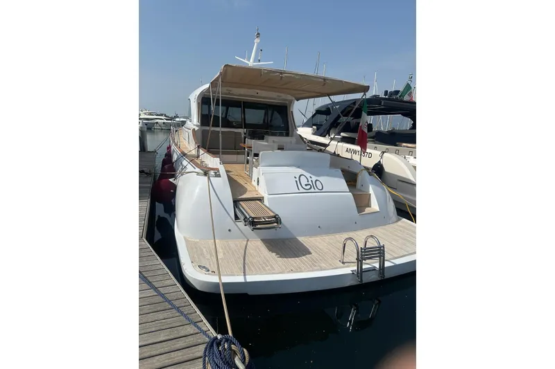  Yacht Photos Pics 2005 Mochi Dolphin 51 yacht docked at marina, featuring spacious deck and elegant design.