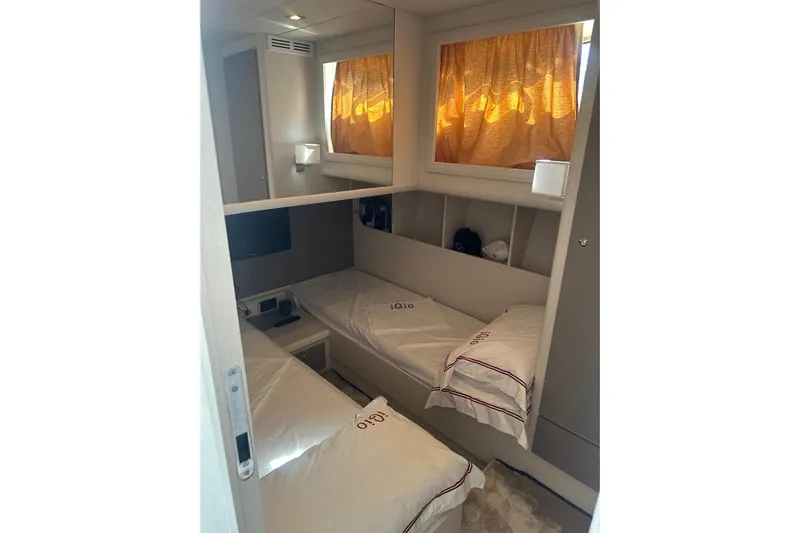  Yacht Photos Pics Cozy cabin interior of 2005 Mochi Dolphin 51 yacht with twin beds and warm lighting.