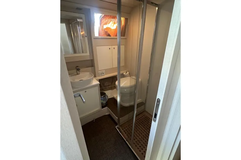  Yacht Photos Pics Compact bathroom in 2005 Mochi Dolphin 51 yacht with shower, sink, and toilet.