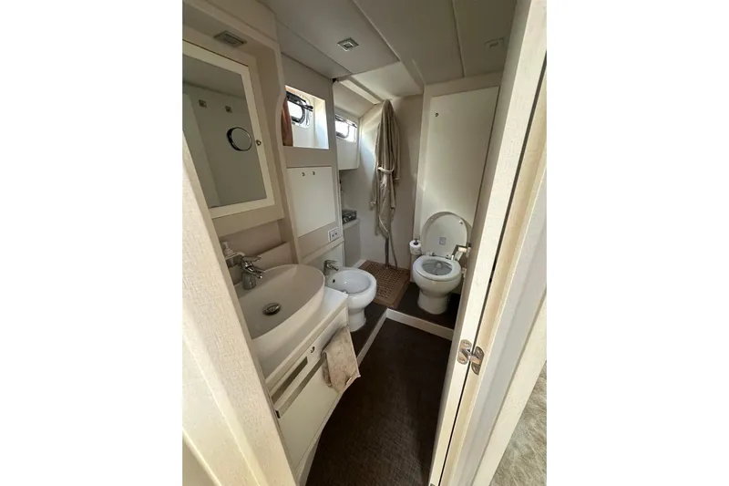  Yacht Photos Pics Bathroom interior of 2005 Mochi Dolphin 51 yacht, featuring sink, toilet, and mirror.