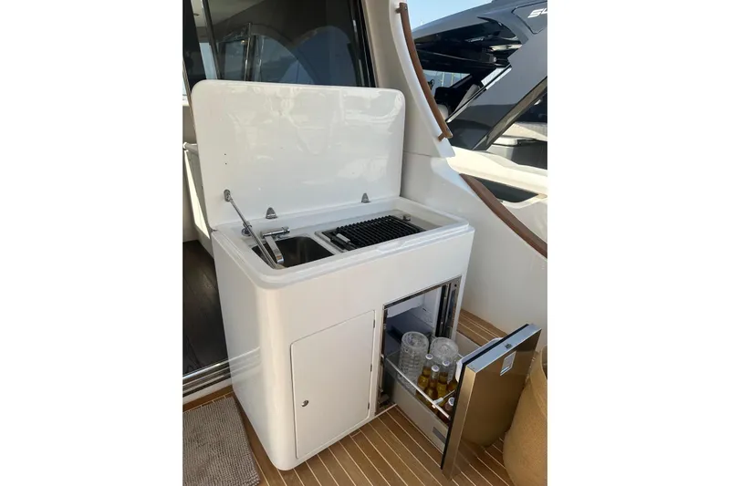  Yacht Photos Pics Outdoor kitchenette on 2005 Mochi Dolphin 51 yacht with sink, grill, and mini fridge.