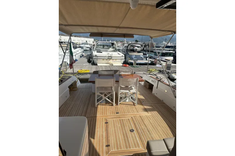  Yacht Photos Pics 2005 Mochi Dolphin 51 yacht deck with seating, docked at marina.