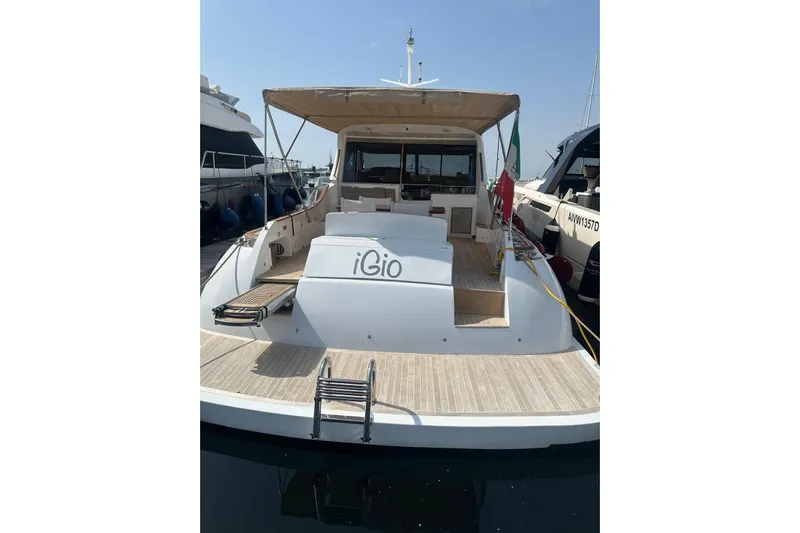  Yacht Photos Pics 2005 Mochi Dolphin 51 yacht with spacious deck and canopy in marina.