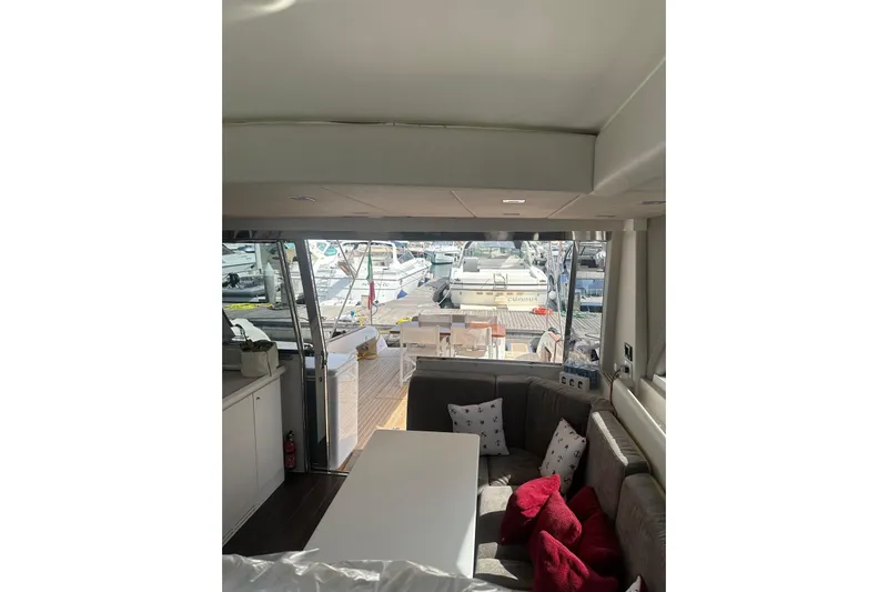  Yacht Photos Pics Interior view of 2005 Mochi Dolphin 51 yacht with cozy seating and marina backdrop.