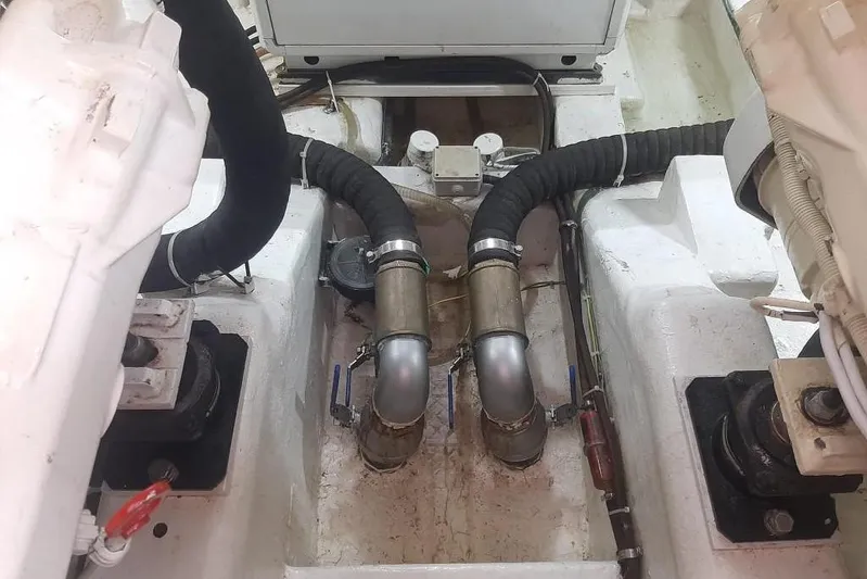  Yacht Photos Pics Engine room of 2005 Mochi Dolphin 51 yacht, featuring dual exhaust pipes and mechanical components.