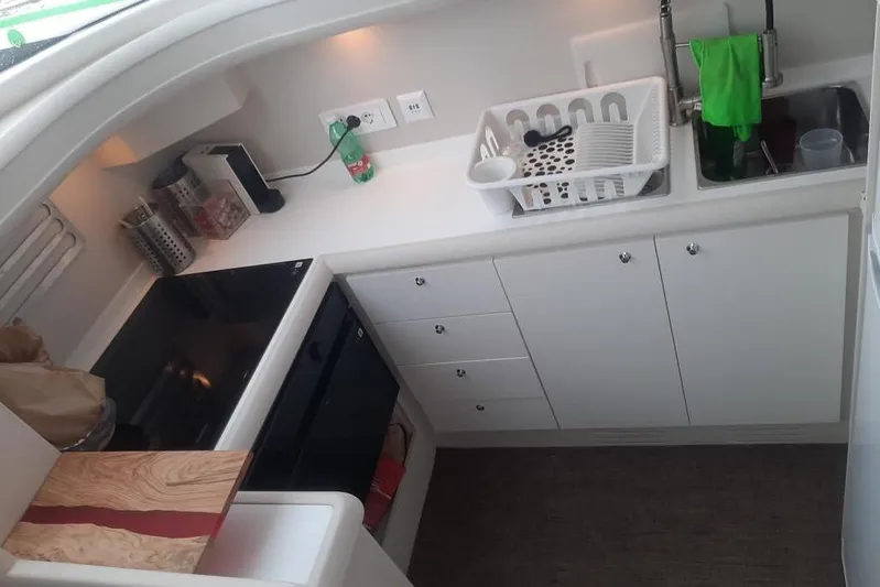  Yacht Photos Pics Compact kitchen area in a 2005 Mochi Dolphin 51 yacht, featuring modern appliances and storage.