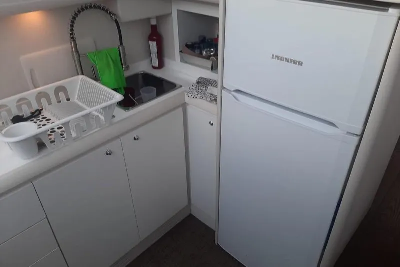  Yacht Photos Pics Compact kitchen in 2005 Mochi Dolphin 51 yacht with sink, fridge, and dish rack.