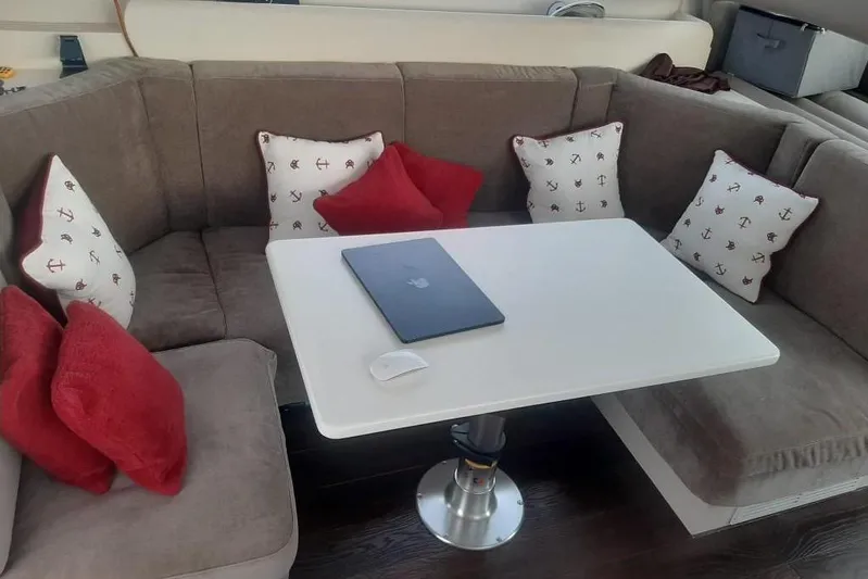  Yacht Photos Pics Cozy seating area on 2005 Mochi Dolphin 51 yacht with cushions and table.