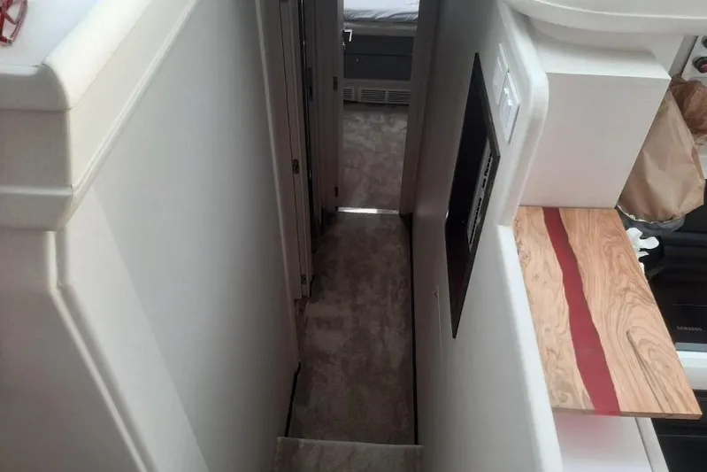  Yacht Photos Pics Narrow hallway inside 2005 Mochi Dolphin 51 yacht, featuring modern interior design elements.