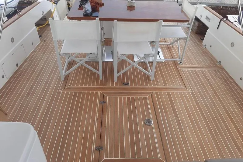  Yacht Photos Pics Teak deck of 2005 Mochi Dolphin 51 yacht with dining table and chairs.