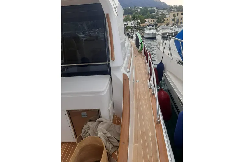  Yacht Photos Pics 2005 Mochi Dolphin 51 yacht docked, showcasing sleek wooden deck and marina view.