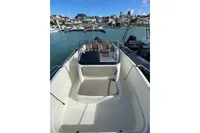 2023 Quicksilver Activ 675 Open boat docked in a marina, showcasing seating and helm.