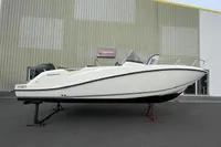 2023 Quicksilver Activ 675 Open boat displayed on a stand outside a building.