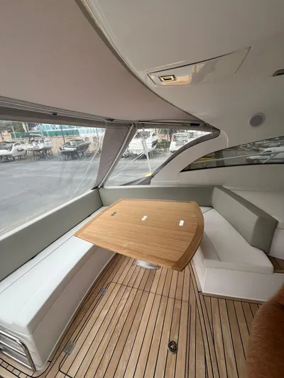 New Sessa C38 Yacht Photos Pics Interior of 2024 Sessa Marine C38 yacht with wooden table and cushioned seating.