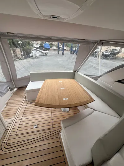 New Sessa C38 Yacht Photos Pics 2024 Sessa Marine C38 yacht interior with wooden table and cushioned seating.