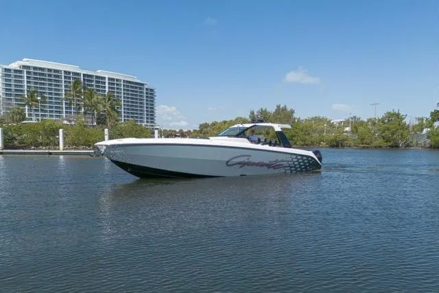  Yacht Photos Pics 2025 Cigarette 42' Auroris boat cruising on a calm waterway with buildings in the background.
