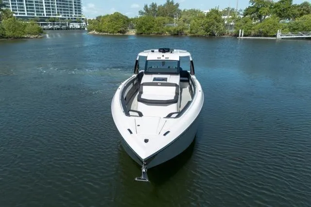  Yacht Photos Pics 2025 Cigarette 42' Auroris boat on calm water, surrounded by greenery.