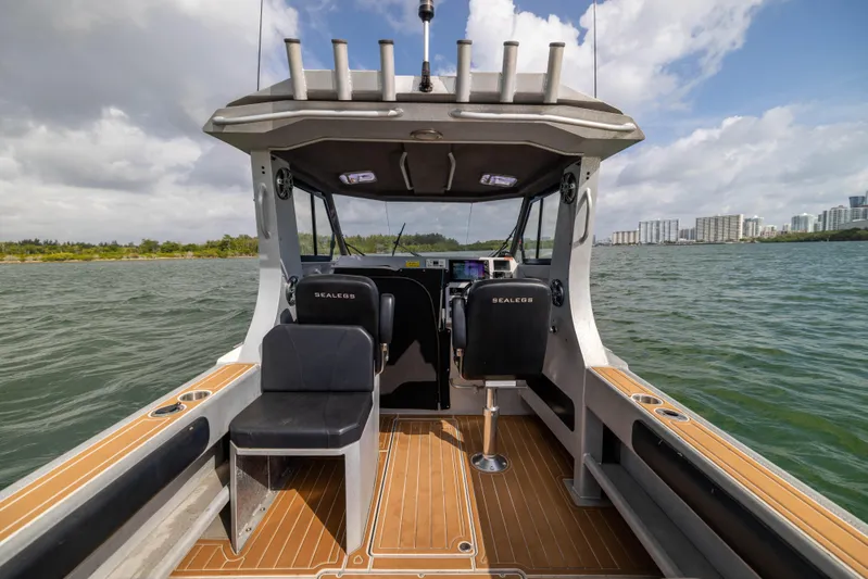 Latitude Yacht Photos Pics 2022 Sealegs 8.5M boat interior with seating, on a sunny day, near city skyline.