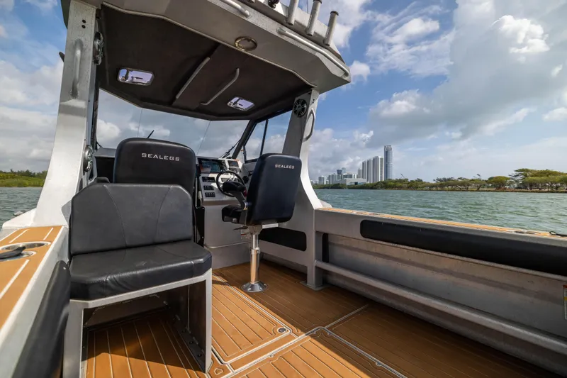 Latitude Yacht Photos Pics Interior of a 2022 Sealegs 8.5M boat with modern seating and scenic waterfront view.
