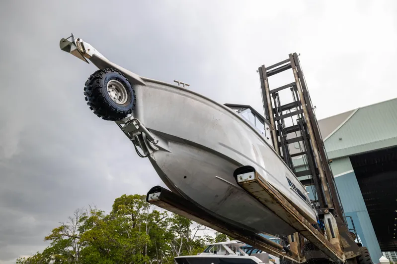 Latitude Yacht Photos Pics 2022 Sealegs 8.5M boat lifted by forklift near a warehouse.