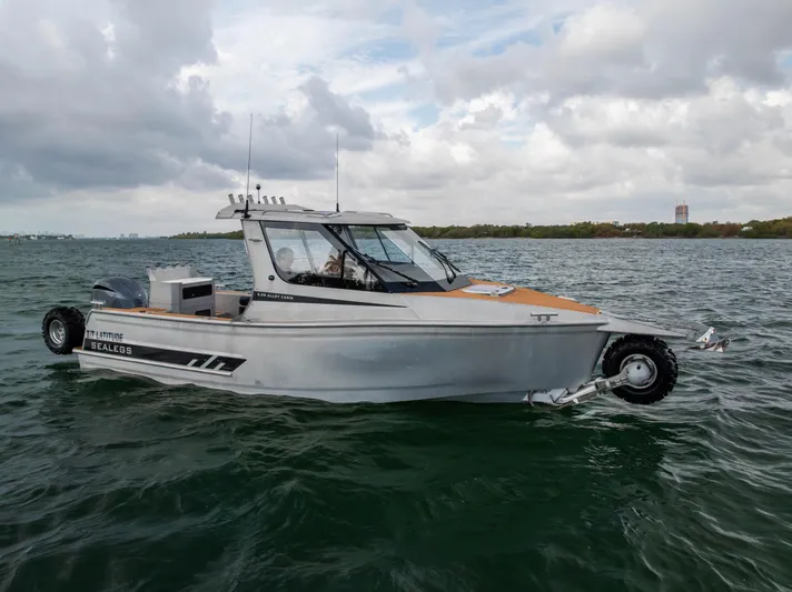 Latitude Yacht Photos Pics 2022 Sealegs 8.5M amphibious boat on water, cloudy sky background.