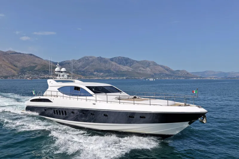 @last Yacht Photos Pics Luxury Leopard 24 yacht cruising on open sea, 2003 model, with scenic mountain backdrop.