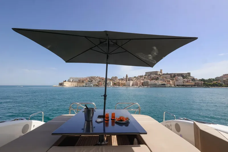 @last Yacht Photos Pics Luxury Leopard 24 yacht deck with umbrella, overlooking coastal cityscape, 2003 model.