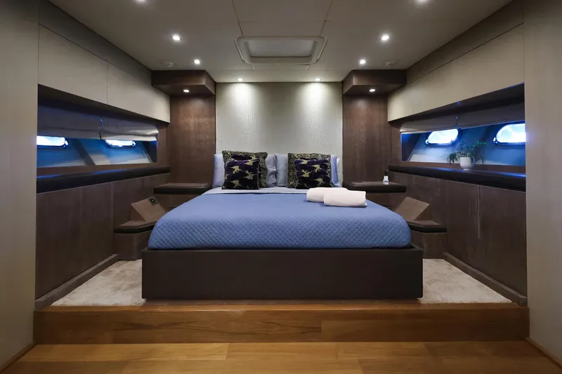 @last Yacht Photos Pics Luxurious bedroom interior of 2003 Leopard 24 yacht with modern design and ambient lighting.