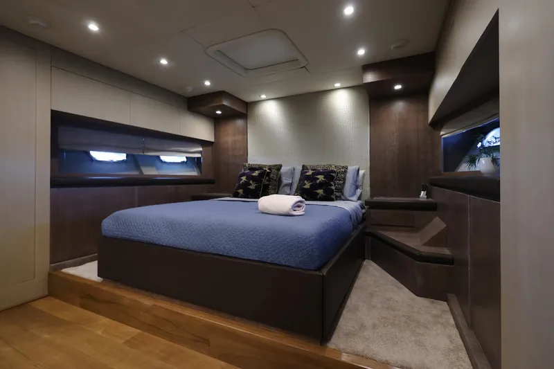 @last Yacht Photos Pics Luxurious bedroom interior of 2003 Leopard 24 yacht with modern design and ambient lighting.