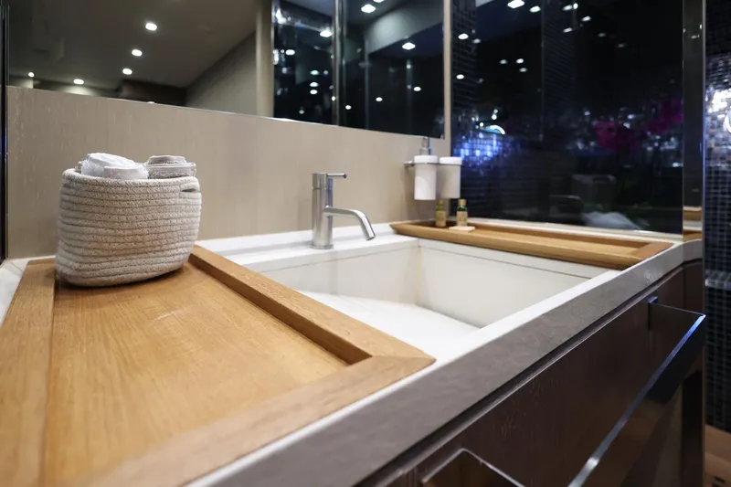@last Yacht Photos Pics Luxurious bathroom sink area on a 2003 Leopard 24 yacht, featuring modern fixtures and wooden accents.
