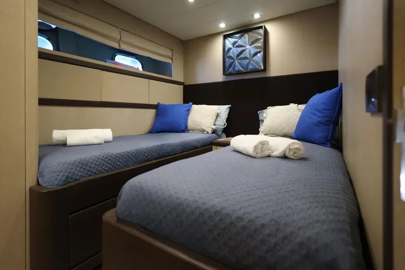 @last Yacht Photos Pics Luxurious twin cabin interior on 2003 Leopard 24 yacht, featuring blue bedding and modern decor.