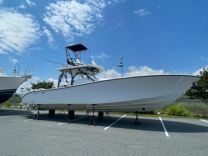  Yacht Photos Pics 2008 Yellowfin 42 boat on stands in a parking lot under a blue sky.