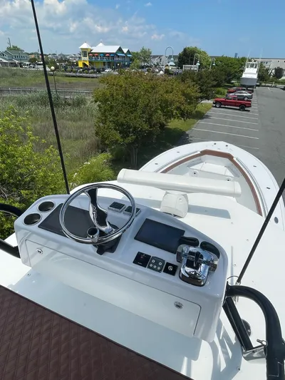  Yacht Photos Pics 2008 Yellowfin 42 boat helm with steering wheel and controls, docked near greenery and parked cars.