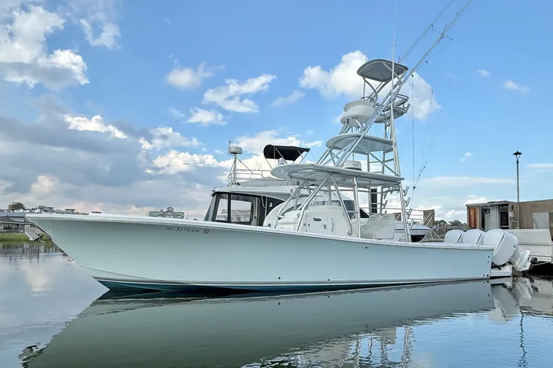  Yacht Photos Pics 2015 Regulator 34 boat docked on calm water under a partly cloudy sky.