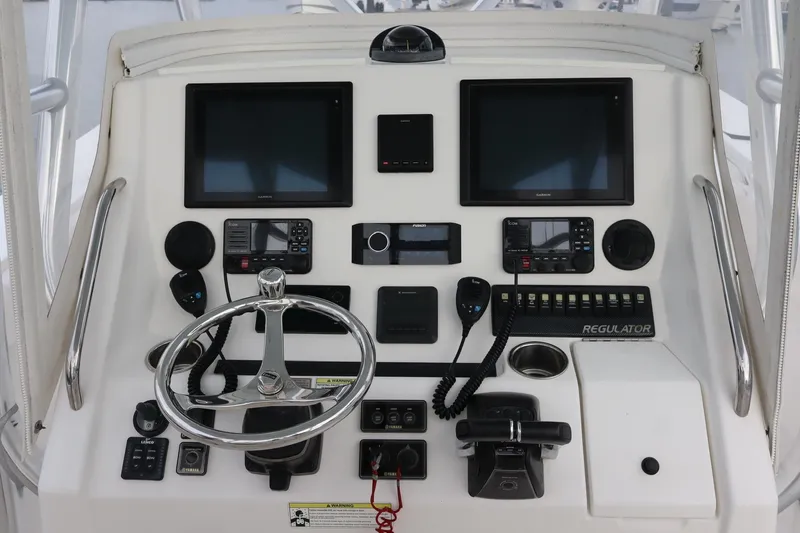  Yacht Photos Pics Control panel of a 2015 Regulator 34 boat with steering wheel and navigation screens.