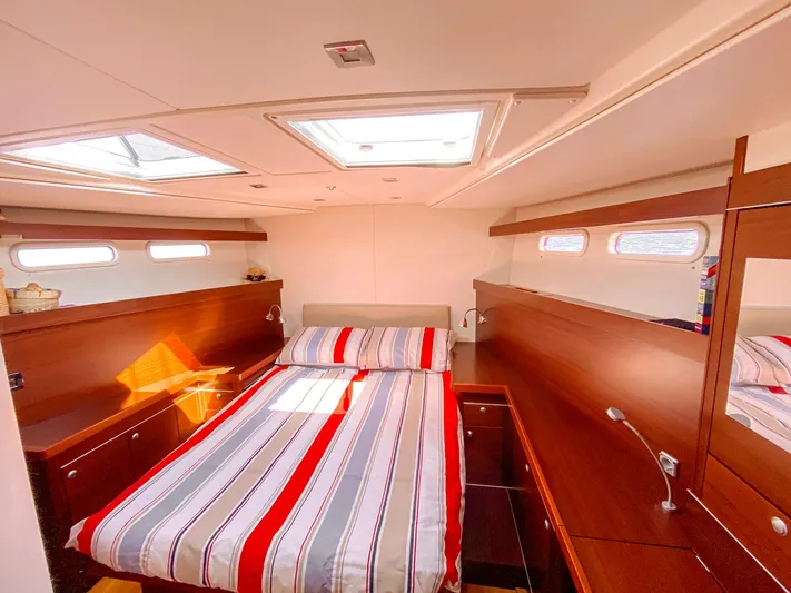  Yacht Photos Pics Interior of 2010 Hanse 545 yacht cabin with striped bedding and wooden furnishings.