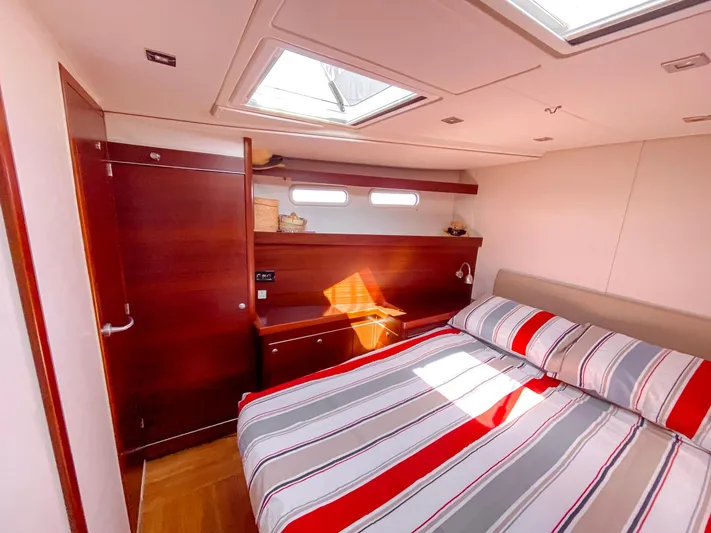  Yacht Photos Pics Luxurious cabin interior of 2010 Hanse 545 yacht with striped bedding and wooden accents.